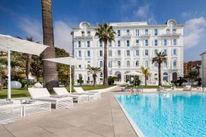 a hotel with a pool and chairs and a building at Miramare The Palace Resort in Sanremo