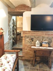 a living room with a table and a tv on a brick wall at Apartamento Rural La Serratilla in Alhama de Aragón