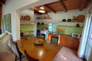 a kitchen with a wooden table with a bowl of fruit on it at Phophonyane Falls Ecolodge in Piggs Peak