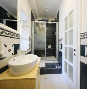 a bathroom with a large white sink and a shower at Petrizio Palace in Zadar