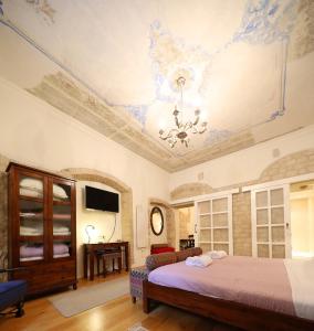 een slaapkamer met een bed en een plafond met een kroonluchter bij Petrizio Palace in Zadar