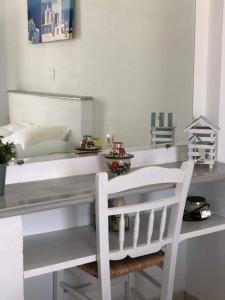 a white desk with a white chair in a room at Marina's Studios Serifos in Livadi