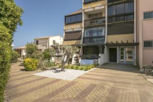 an apartment building with a courtyard in front of it at VIEW port venus naturiste in Cap d'Agde