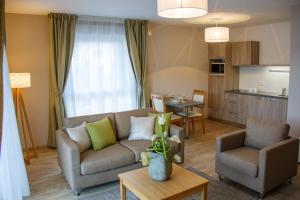 ティオンヴィルにあるDomitys Le Pavillon de Dianeのソファとテーブルのあるリビングルーム