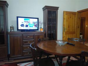 een woonkamer met een tafel en een televisie op een kast bij Dom Eli in Pomorie