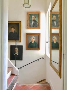 a hallway with portraits of men on the wall at Le Clos Saluces in Avignon