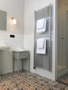 a bathroom with a towel rack with a sink and a shower at Le Clos Saluces in Avignon