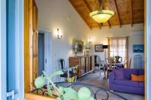 - un salon avec un canapé violet et une table dans l'établissement Marianna Cottage, à Palaia Fokaia