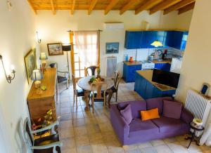 a living room with a purple couch and a table at Marianna Cottage in Palaia Fokaia