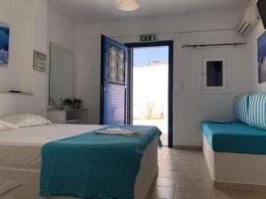 a bedroom with a bed and a couch and a window at Marina's Studios Serifos in Livadion