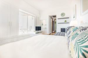 カスカイスにあるCascais Atlantic Viewsの白いベッドルーム(ベッド1台、テレビ付)