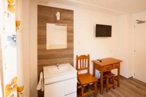 a small bathroom with a sink and a table at Serramar in Benalmádena