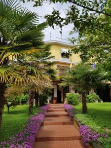 una passerella di fronte a un edificio con fiori viola di Hotel Due Fontane a Casalpusterlengo