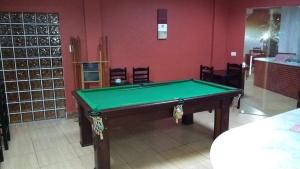 a green pool table in a room with chairs at Hotel Basilio Reformado pelo SBT in Mongaguá