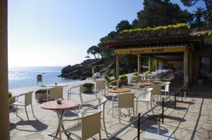 a restaurant on the beach with tables and chairs at Eden Playa Standing in Sant Antoni de Calonge