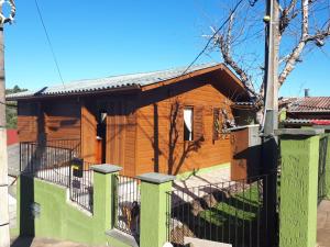 una casa de madera con una valla delante en Casa Jardim de Gramado, en Gramado