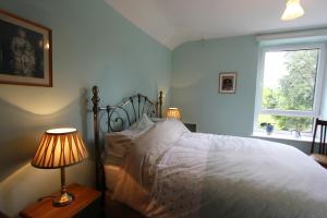 a bedroom with a bed with two lamps and a window at 81 Eastgate in Cowbridge