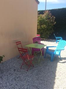 um grupo de cadeiras e uma mesa e cadeiras em Chambres Les Passiflores em Saint-Palais-sur-Mer