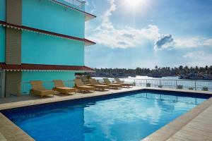 un hotel con piscina con sillas y un edificio en Indy Waterfront Resort en Cavelossim