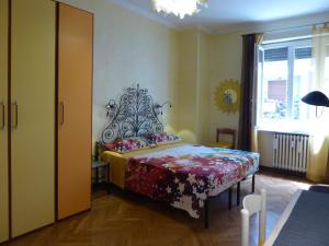 um quarto com uma cama com colcha floral e uma janela em Casa Clemente in Cit Turin em Turim