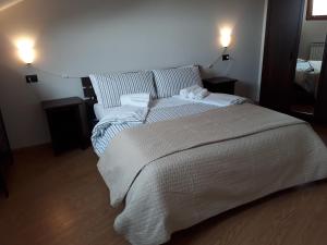 CarrùにあるYour House in Langaのベッドルーム(白い大型ベッド、ランプ2つ付)