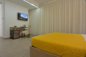 a bedroom with a bed and a desk and a television at Il Rifugio Dei Templari in Lecce