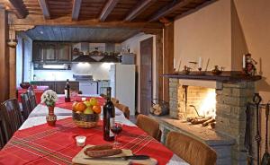 a kitchen with a dining table with a fireplace at Kenara Guest House in Zheravna