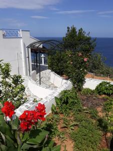 a stairway with red flowers in front of a building at Korasida Blue Coast in Akhladherí