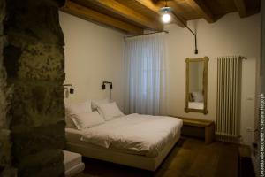 a bedroom with a white bed with a mirror at Locanda alla Beccherie in Trieste