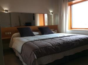 a large bed in a bedroom with a window at Hotel Viaurelia in Montblanc