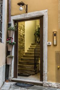 uma porta para um edifício com escadas e vasos de plantas em Locanda alla Beccherie em Trieste