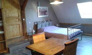 a bedroom with a bed and a wooden table at Val de Gée à 20 mn du circuit 24 h du Mans in Maigné