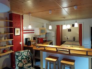 a kitchen with a long counter and some chairs at Home Nantua studio meublés Ain-Jura in Nantua