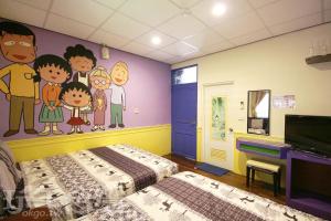 a bedroom with a cartoon painting on the wall at Her Home Homestay in Green Island