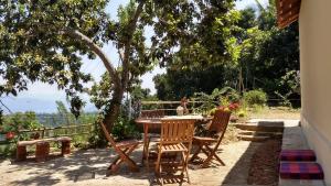 a table and chairs on a patio under a tree at The Pepper Cottage in Gomagoda