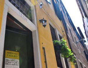 a yellow building with a door and plants on it at Residenza Favaro in Venice +12 photos