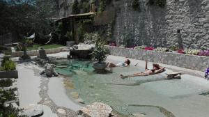 two people laying in a swimming pool in a backyard at La Casa del Gelsomino in Ragusa +51 photos