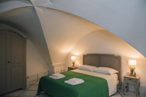 sypialnia z zielonym łóżkiem i 2 stolikami nocnymi w obiekcie L' Ambasciata Gaeta w mieście Gaeta