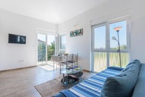 a living room with a blue couch and a table at Guesthouse Bencun Medulin in Medulin