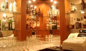 a bar with bottles of wine and glasses on it at The Bournemouth Maemar Hotel in Bournemouth