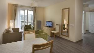 ティオンヴィルにあるDomitys Le Pavillon de Dianeのソファとテーブルとテレビのあるリビングルーム