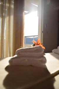 a pile of towels sitting on a bed with a window at Belvedere Adriatica in Qeparo