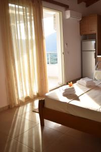 a bedroom with a bed and a large window at Belvedere Adriatica in Qeparo