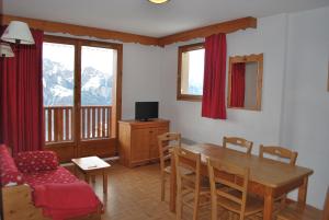 ein Wohnzimmer mit einem Holztisch und einem Sofa in der Unterkunft Les Gentianes by Actisource in Puy-Saint-Vincent