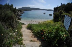 a path leading to a beach with a sign at VKastri in Vasiliki