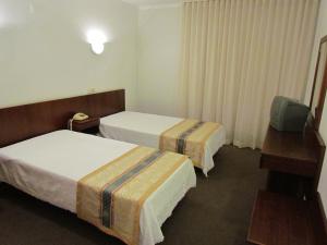 a hotel room with two beds and a television at Sao Tomas in Fátima +30 photos