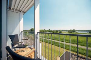 a balcony with a table and chairs and a view of a field at Van der Valk Hotel ARA Zwijndrecht in Zwijndrecht