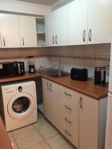 a kitchen with a washing machine and a sink at Departamentos Amoblados La Hermandad in Antofagasta