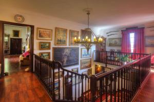 a staircase in a room with paintings on the wall at Hotel del Almirante in Es Castell