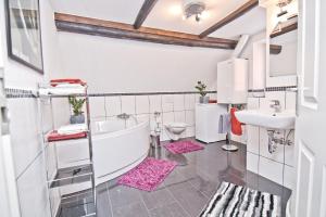 a bathroom with a tub and a sink and a toilet at Gusto Stolberg in Stolberg i. Harz +39 photos